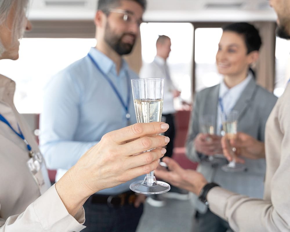 Corporate event social hour of a person holding a champagne glass